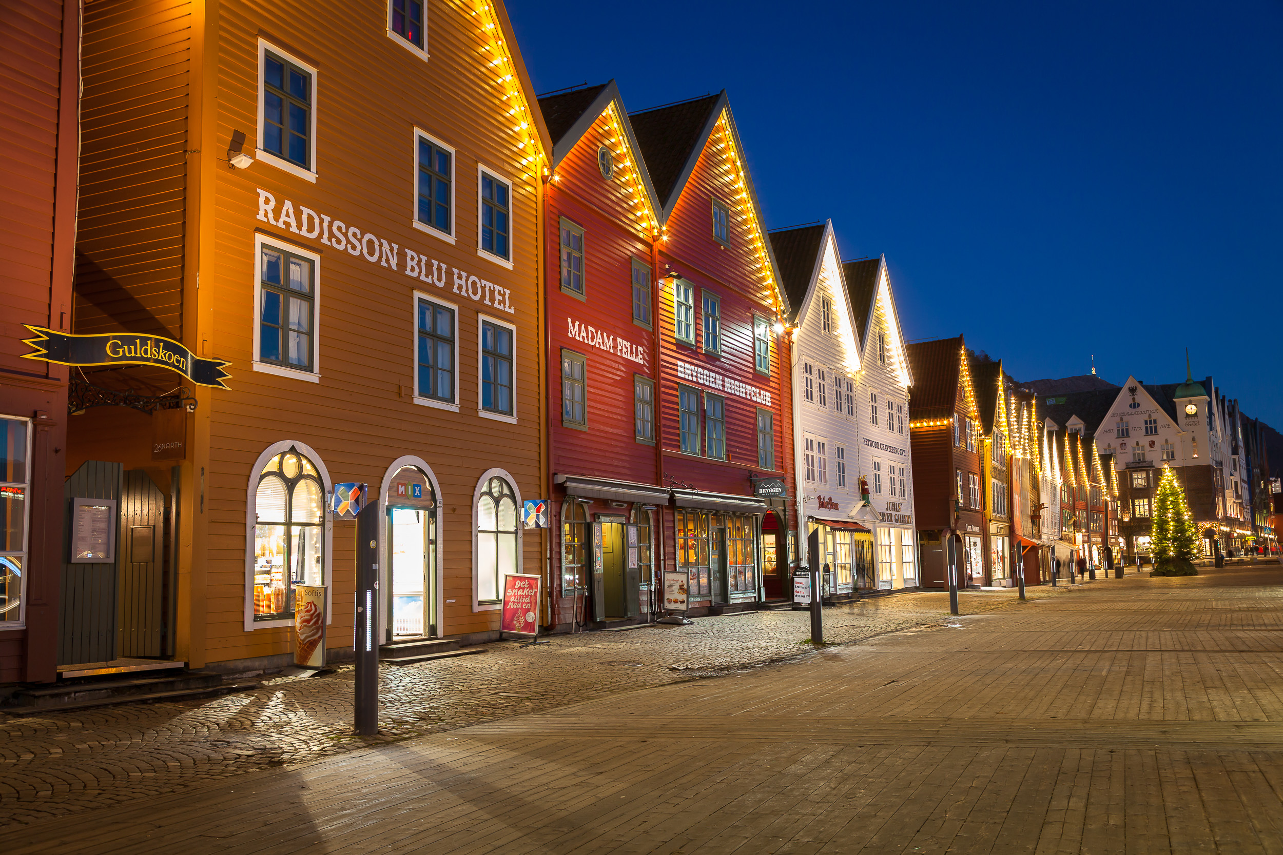 Qué ver en Bergen en un día de crucero 6 Bryggen iluminado de noche reflejándose en el fiordo de Bergen